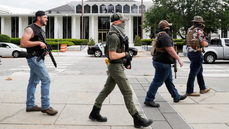 Armed group gathers and walks through downtown