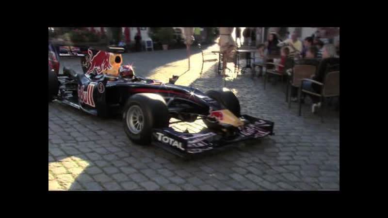 Sebastian Vettel mit dem Formel 1 Boliden durch die Straßen seiner